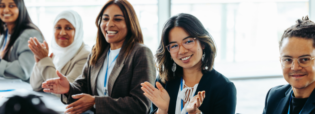diverse coworkers clapping and smiling during team meeting