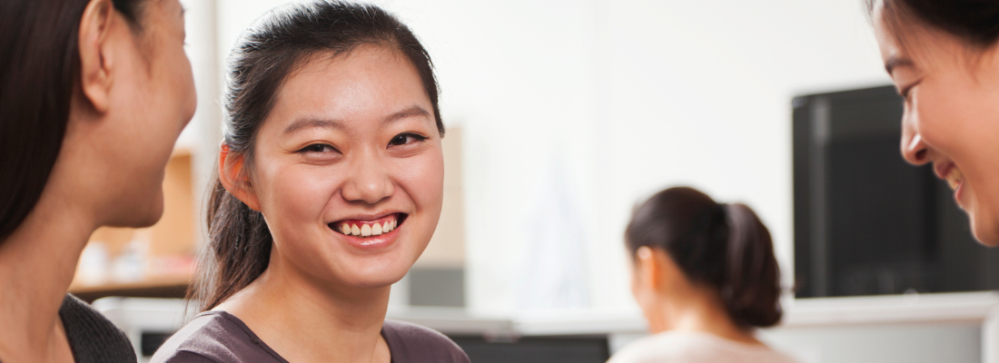 Asian woman smiling with colleagues