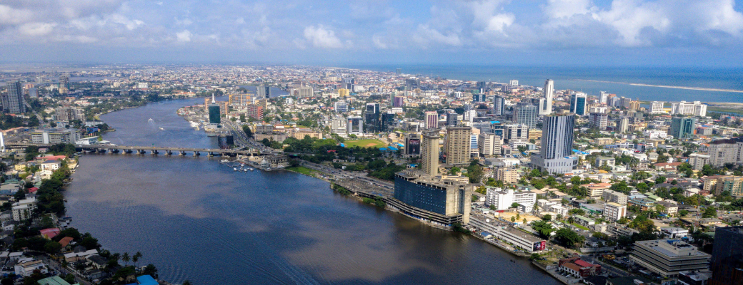 Landscape image of a city in Nigeria - a river with a bridge and buildings
