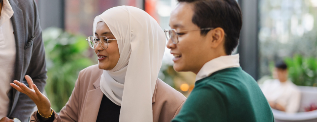 Woman wearing hijab and male with glasses looking left - stock
