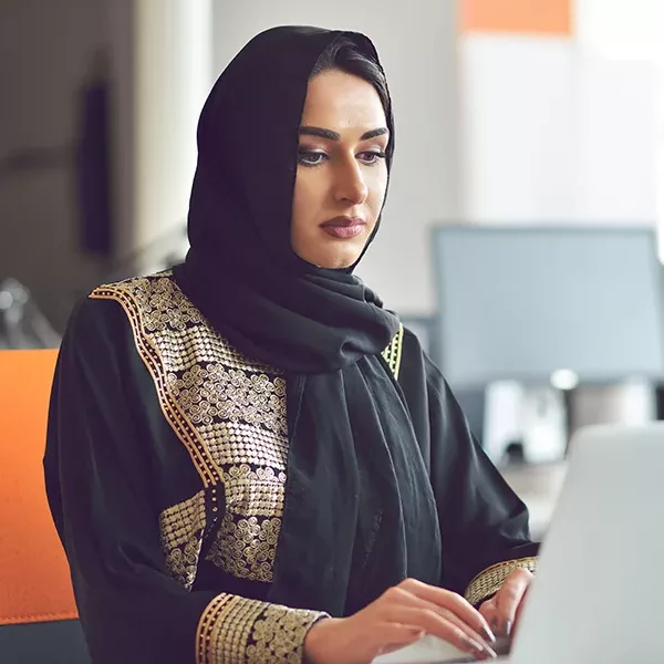 woman wearing a hijab learning about global diversity on a laptop