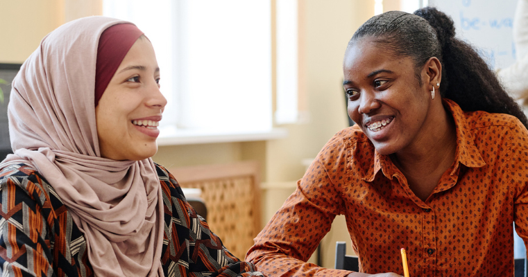 two people working together and smiling
