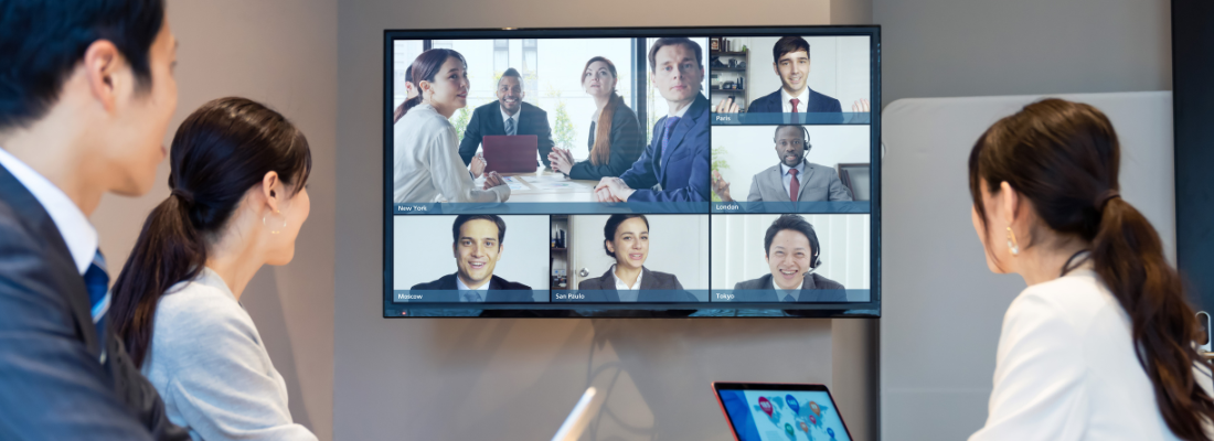 three people in a business meeting looking at a screen where others are attending virtually