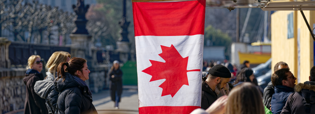 people outside standing near a Canadian flag