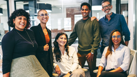 diverse team posing together in the office