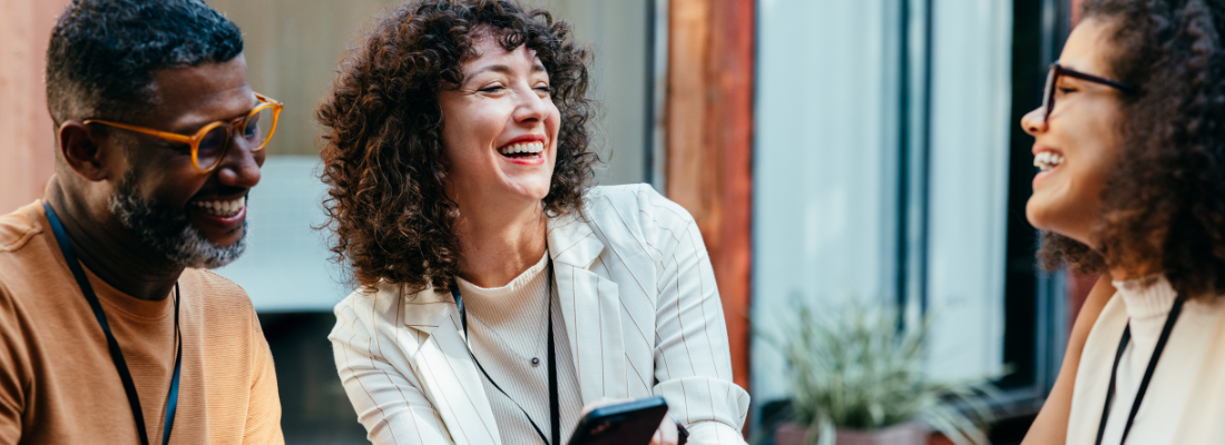 diverse professionals smiling in conversation in a workplace